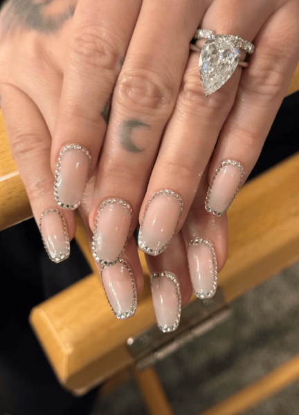 Demi Lovato's hands wearing a rhinestoneoutlined manicure